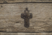 A metal cross on wood
