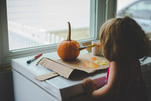 kid painting a pumpkin 