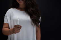 a young woman holding a candle 
