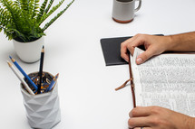 a man reading a Bible at a desk