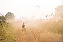 man on a motorcycle on a foggy dirt road 