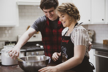 couple baking cookies in a kitchen 