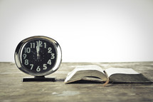 alarm clock and an open Bible