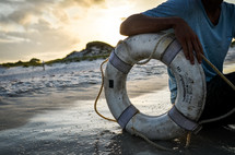 man and a life ring on a beach