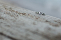 engagement ring on concrete with sand 