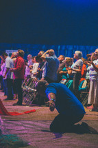 kneeling and prayer and  praising God at a worship service 