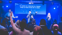 people singing on stage at a worship service 