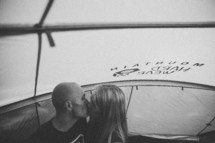 A couple kissing in a tent. 