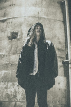 woman in a hooded jacket standing under a street lamp 