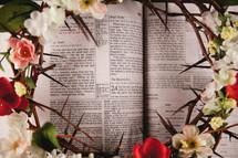 flowers and crown of thorns on the pages of a Bible 