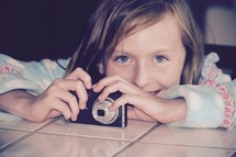 a little girl holding a camera 