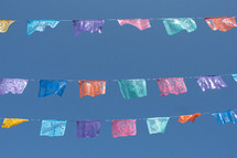 colorful banners hanging against a blue sky 