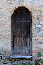 A wooden door in a stone wall.