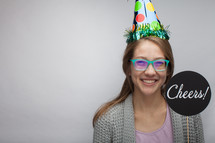 a woman wearing a party hat and holding a cheers sign 