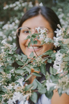 a smiling woman standing in a flowering tree 
