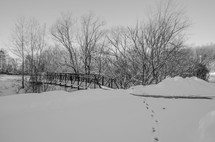 footprints in snow and a foot bridge 