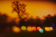 colorful bokeh lights outdoors at sunset with orange glow 