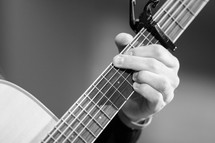 fingers on the neck of a guitar