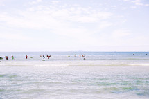 people swimming and playing in the ocean 