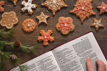 a woman reading a Bible and baking gingerbread Christmas cookies 