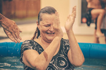 A woman clapping after she is baptized.