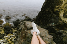 man sitting on a rocky shore 