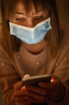 a woman texting wearing a face mask 