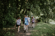teen girls hiking through the woods 