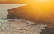 sea cliffs along a shore at sunset 