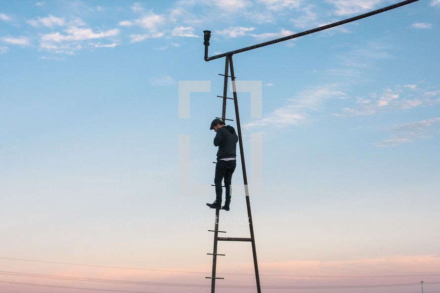 Man climbing a utility ladder.