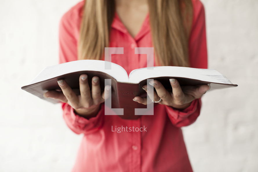 torso of a young woman reading a Bible 