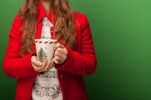 a woman in a red peacoat holding a mug