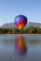 Colorful Hot Air Balloon flying over a Colorado lake
