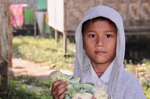 a young boy holding cauliflower 