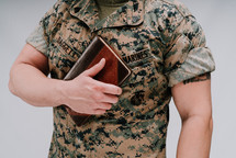 a Marine holding a Bible against his chest 