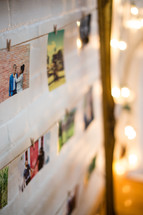 A wall of photographs hung by clothespins to twine.
