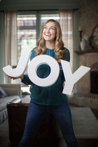 a woman holding a sign of the word joy