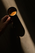 hand on an Espresso Coffee Cup with sunbeam 