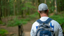 a man backpacking through a forest 