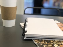 notebook and coffee cup on a table 