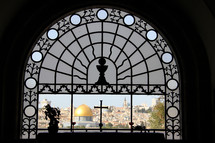 Ornate church window overlooking the old city of Jerusalem and the Dome of the Rock