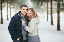 a couple hugging in the snow 