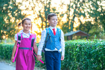 kids walking to school holding hands 