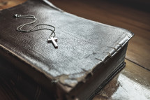 cross necklace on the cover of a Bible 