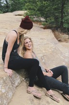 women sitting on rocks talking 