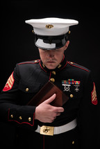 marine holding a Bible against his chest 