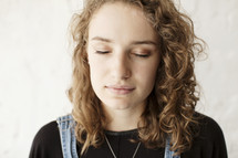 young brunette woman with closed eyes in prayer