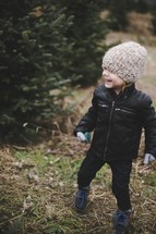 a toddler boy in a Christmas tree lot 