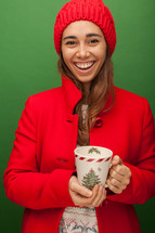 a woman in a red trench coat holding a mug 