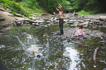 brother and sister playing in a stream 